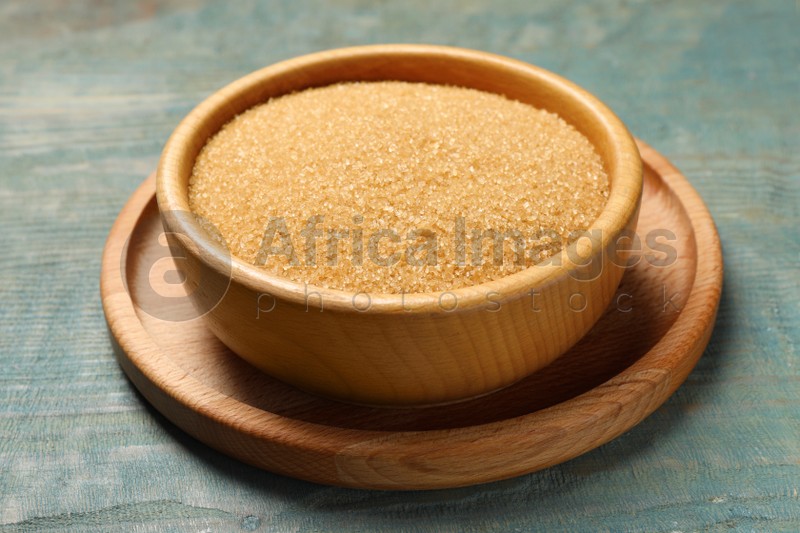 Photo of Brown sugar in bowl on light blue wooden table