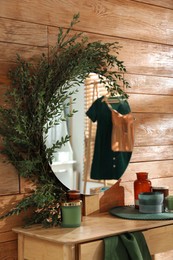 Photo of Stylish dressing table and mirror decorated with green eucalyptus in room
