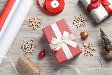 Flat lay composition with beautiful Christmas gift boxes and wrapping paper on white wooden table