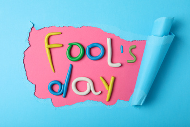 Flat lay composition with words FOOL'S DAY made of clay on color background. April holiday