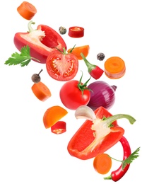 Set of different fresh vegetables and spices falling on white background