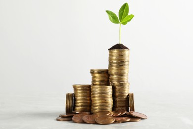 Stacked coins and green sprout on white background. Investment concept
