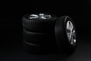 Set of wheels with winter tires on black background