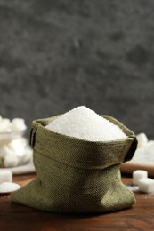 Photo of Granulated sugar in sack on wooden table