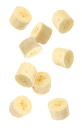 Slices of tasty ripe banana falling on white background