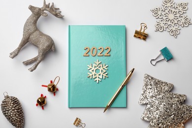 Turquoise planner and Christmas decor on white background, flat lay. 2022 New Year aims