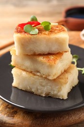 Delicious turnip cake with microgreens on wooden table, closeup
