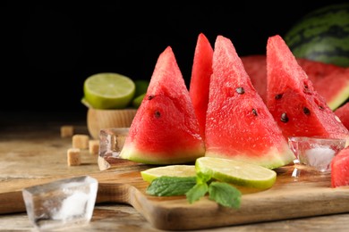 Tasty juicy watermelon, ice and lime slices on wooden table, space for text