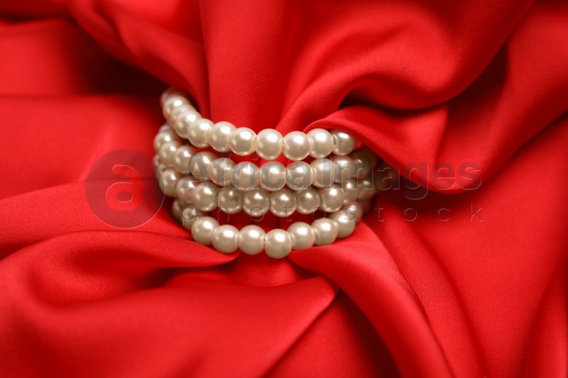 Beautiful pearls with red silk as background, closeup