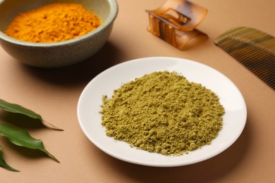 Photo of Henna and turmeric powder on coral background. Natural hair coloring