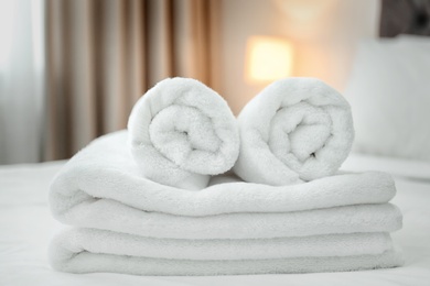 Clean towels on bed in modern hotel room