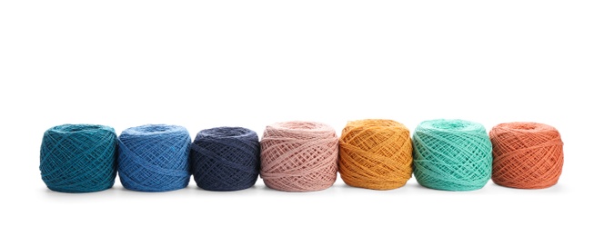 Clews of colorful knitting threads in row on white background