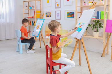 Cute little children painting during lesson in room