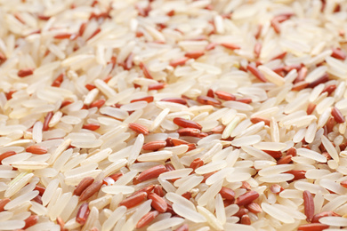 Mix of brown and polished rice as background, closeup