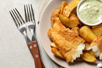 Plate with British Traditional Fish and potato chips on grey background