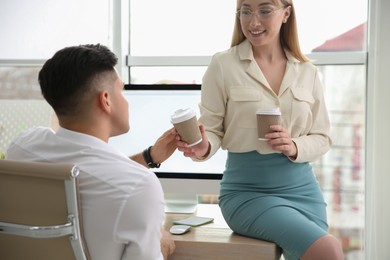 Colleagues flirting with each other during coffee break in office
