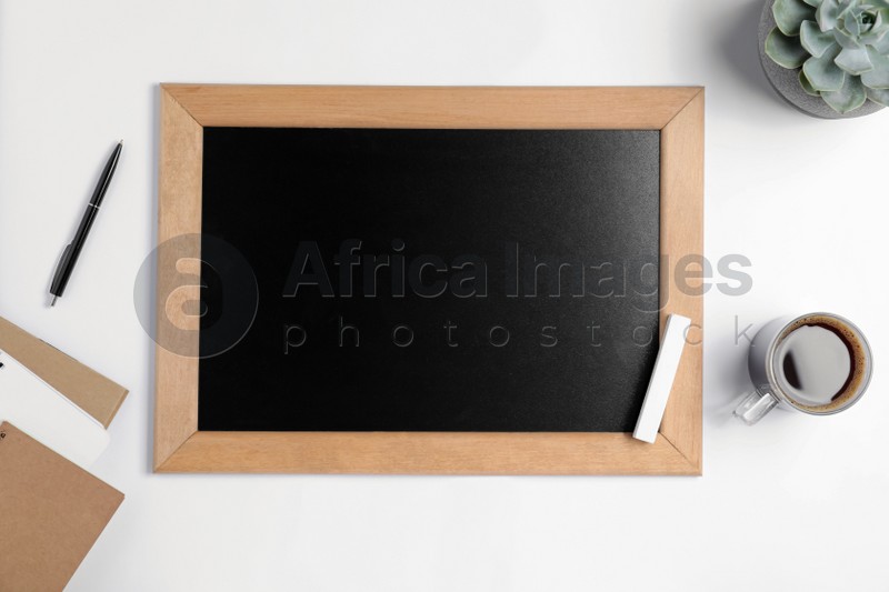 Flat lay composition with small chalkboard on white background, space for text