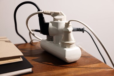 Smoking plug in power strip on wooden table, closeup. Electrical short circuit