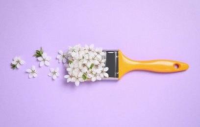 Paint brush and beautiful flowers on pale violet background, flat lay