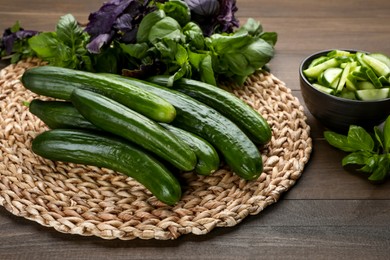 Fresh ripe cucumbers and basil on wooden table
