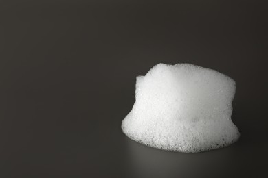 Drop of fluffy bath foam on grey background. Space for text