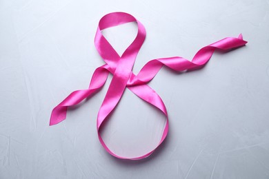 Photo of 8 March greeting card design with pink ribbon on light grey background, top view. International Women's day
