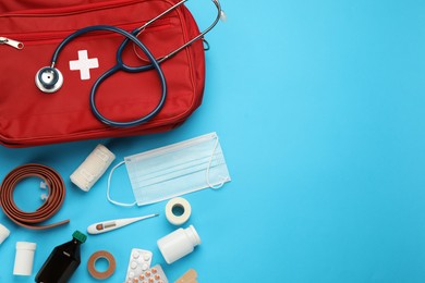 Flat lay composition with first aid kit on light blue background, space for text