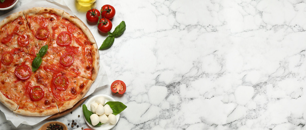Image of Top view of hot delicious pizza on light marble table, space for text. Banner design 