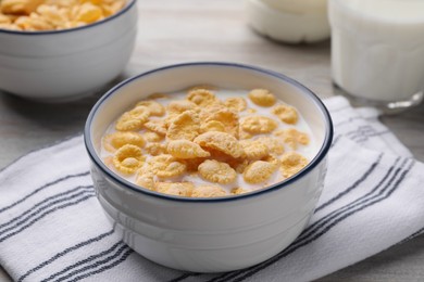 Tasty cornflakes with milk served in bowl on table