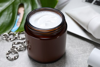 Jar of hand cream on light grey table, closeup