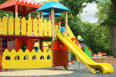 Photo of New colorful castle playhouse with slide on children's playground