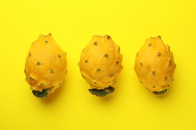 Delicious pitahaya fruits on yellow background, flat lay