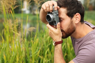 Photo of Man with camera taking photo outdoors, space for text. Interesting hobby