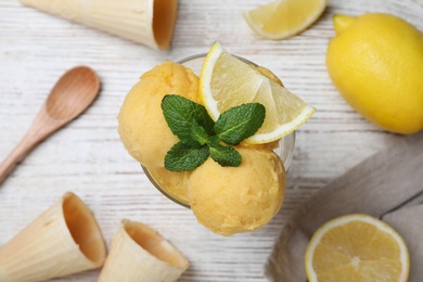 Photo of Yummy lemon ice cream served on white wooden table, flat lay