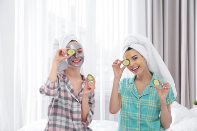 Young friends with facial masks having fun in room at pamper party