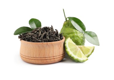 Dry bergamot tea leaves in wooden bowl and fresh fruits on white background