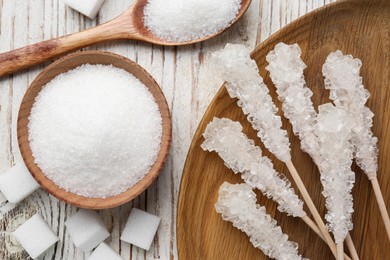 Different types of sugar on white wooden table, flat lay
