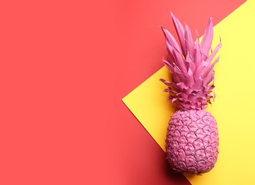 Photo of Pink pineapple on color background, top view with space for text. Creative concept