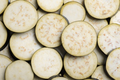 Slices of raw eggplant as background, top view