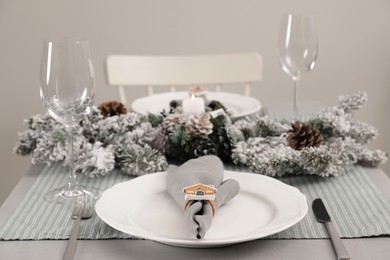 Photo of Festive place setting with beautiful dishware, cutlery and fabric napkin for Christmas dinner on grey table