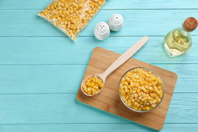 Flat lay composition with frozen sweet corn on light blue wooden table. Vegetable preservation