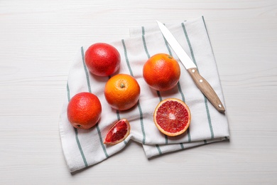 Fresh ripe red oranges on white wooden table, flat lay