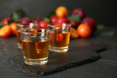 Photo of Delicious plum liquor on black table. Homemade strong alcoholic beverage