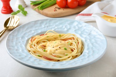 Delicious spaghetti with meat and cheese sauce on light grey table