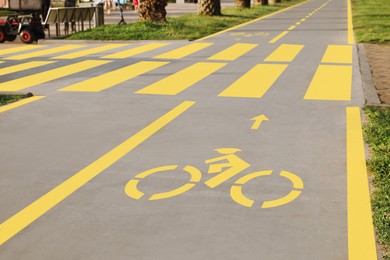 Bike lane with painted yellow bicycle sign and pedestrian crossing outdoors