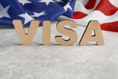 Word Visa and American flag on light grey table, space for text