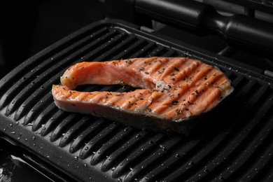 Photo of Cooking salmon. Grill with tasty fish steak and spices