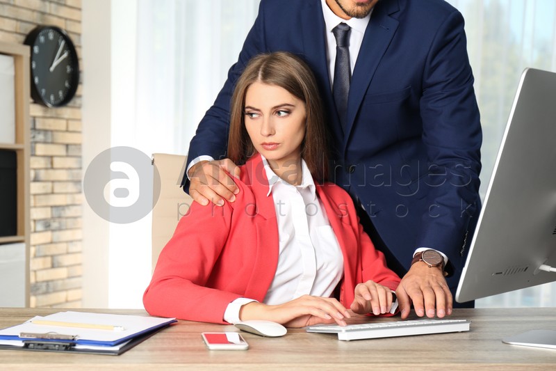 Boss molesting his female secretary in office. Sexual harassment at work