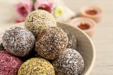 Photo of Different delicious vegan candy balls in bowl, closeup