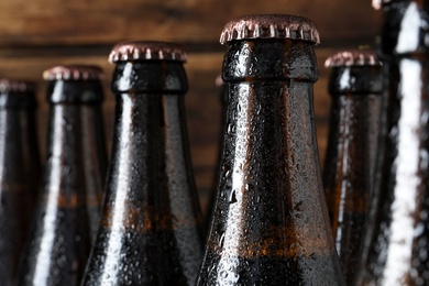 Photo of Bottles of beer on wooden background, closeup. Space for text
